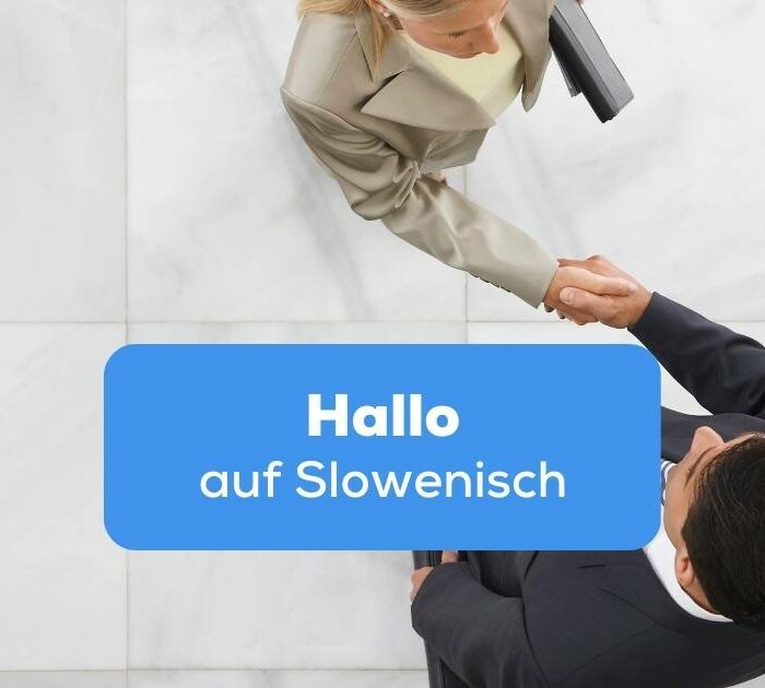 Vogelperspektive Frau und Mann im Anzug schütteln sich die Hände um Hallo auf Slowenisch zu sagen