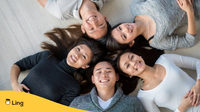 5 Japaner liegen im Kreis auf dem Boden