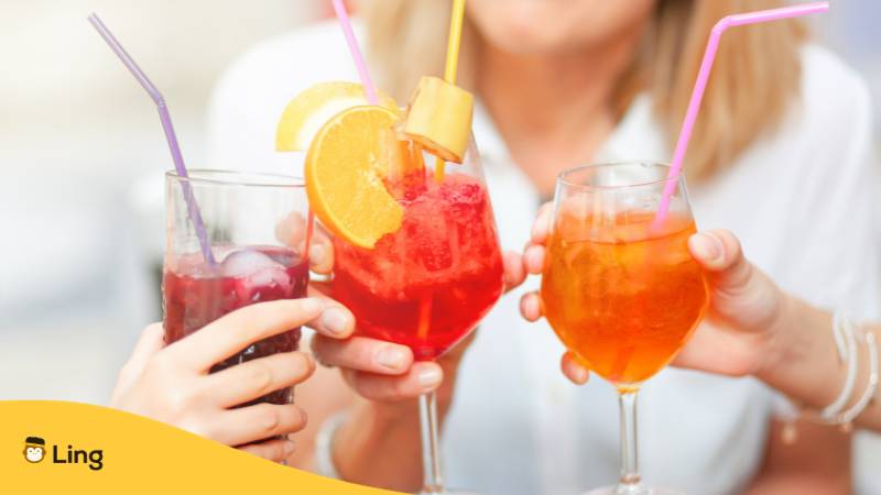 Gläser mit verschienenen farbigen Cocktails werden angestoßen und Prost auf Estnisch gesagt