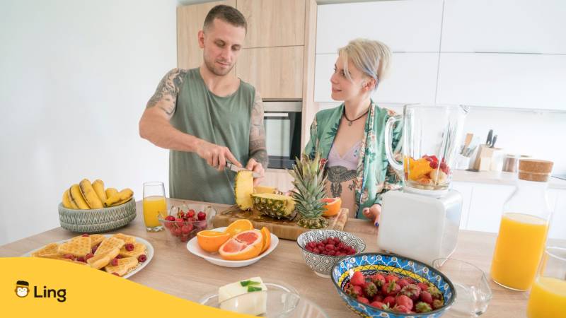 Ein Pärchen benutzt estnische Redewendungen während es Obst schneidet

